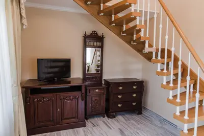 a staircase with a television and a dresser with a mirror at Palace Inn in Jíloviště