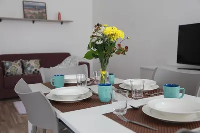 a dining room table with white plates and a vase of flowers at Arbes 12 in Prague