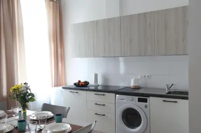 a kitchen with a washing machine and a table at Arbes 12 in Prague