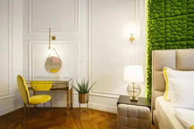 a bedroom with a desk and a green wall at Urban Premier Suite in Prague
