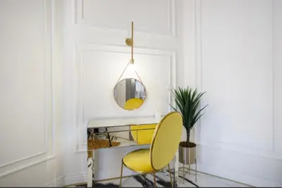 a room with two yellow chairs and a mirror at Urban Premier Suite in Prague