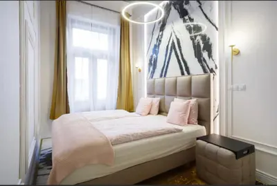 a bedroom with a large bed with pink pillows at Urban Premier Suite in Prague
