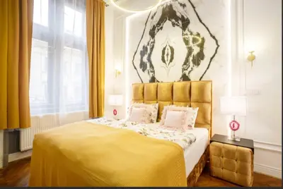 a bedroom with a large bed with a yellow blanket at Urban Presidential Suite in Prague