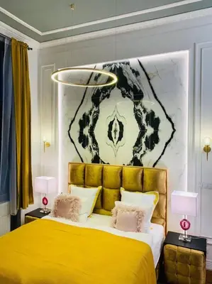 a bedroom with a yellow bed and a painting on the wall at Urban Presidential Suite in Prague