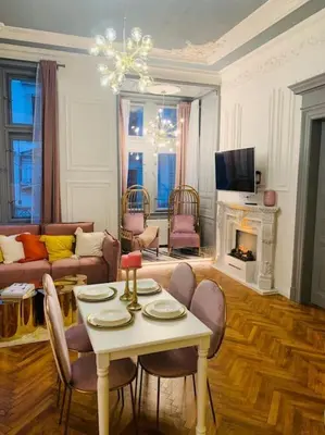 a living room with a table and chairs and a fireplace at Urban Presidential Suite in Prague