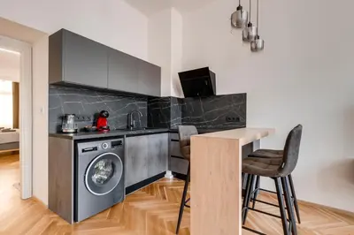 a kitchen with a washing machine and a table at New Town Oases Apartment in Prague