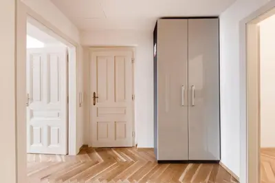 an empty room with two white doors and wooden floors at New Town Oases Apartment in Prague