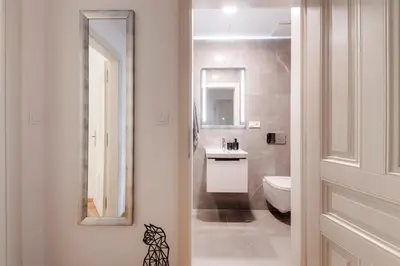 a bathroom with a sink and a toilet and a mirror at New Town Oases Apartment in Prague