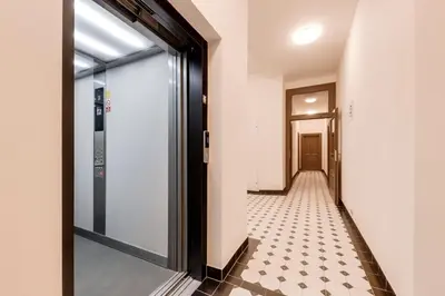 a hallway with a glass door and a tiled floor at New Town Oases Apartment in Prague