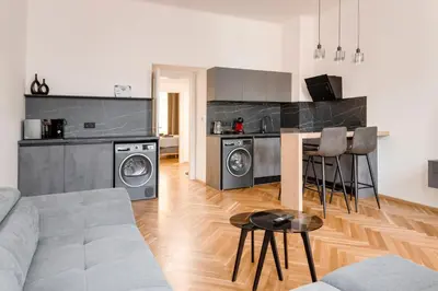 a living room with a couch and a kitchen at New Town Oases Apartment in Prague