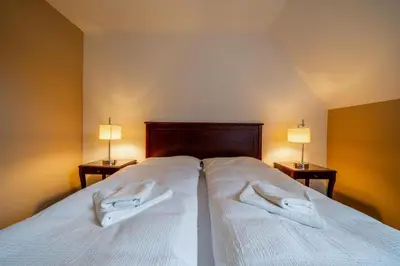 a bedroom with a bed with two white towels on it at Villa Mandát in Šlemín