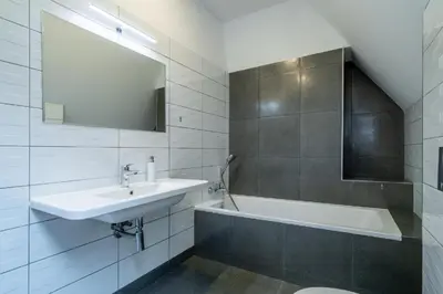 a white bathroom with a sink and a bath tub at Villa Mandát in Šlemín