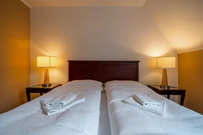 two white towels on a bed with two lamps at Villa Mandát in Šlemín