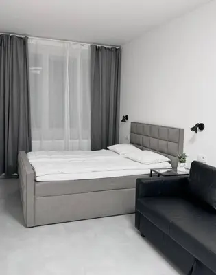 a bedroom with a large bed and a couch at NEW Modern Large Apartment in New Town 3BDR in Prague