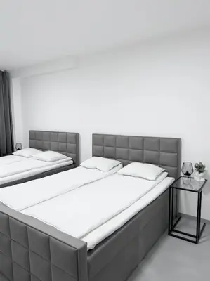 two large beds in a bedroom with a side table at NEW Modern Large Apartment in New Town 3BDR in Prague