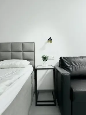a bedroom with a bed and a side table with a lamp at NEW Modern Large Apartment in New Town 3BDR in Prague