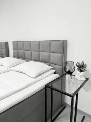a bed with a glass table with a lamp on it at NEW Modern Large Apartment in New Town 3BDR in Prague