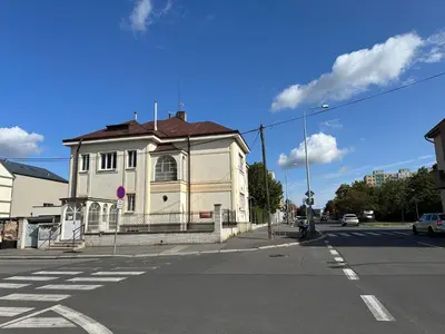 a white building with a red roof on a street at Bene Dormies in Prague