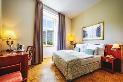 a hotel room with a bed and a desk and a window at Wenceslas Square Hotel - Czech Leading Hotels in Prague