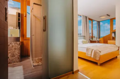 a bedroom with a bed and a bathroom with a shower at Wenceslas Square Hotel - Czech Leading Hotels in Prague