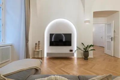 a living room with a tv in a white wall at Arch IV. in Prague