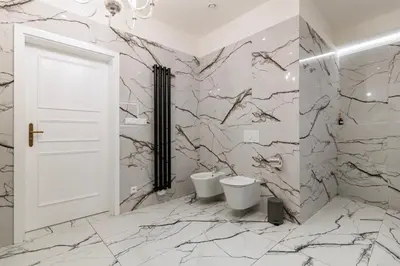 a bathroom with two toilets and marble walls at Arch IV. in Prague