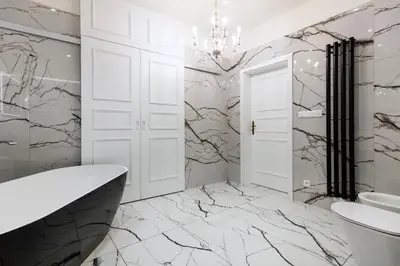 a bathroom with marble walls and a chandelier at Arch IV. in Prague