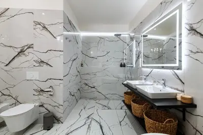 a bathroom with marble walls and a sink and a toilet at Arch IV. in Prague