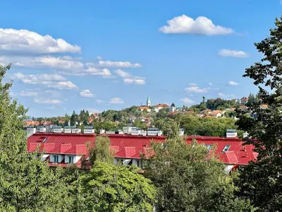 a red roofed building in a city with trees at Jana's WoW apt, 2BR, Metro next door, near the airport in Prague