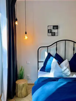 a bedroom with a bed with blue sheets and pillows at Jana's WoW apt, 2BR, Metro next door, near the airport in Prague