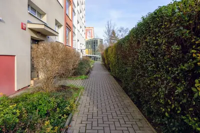 a brick walkway between two buildings next to a hedge at Jana's WoW apt, 2BR, Metro next door, near the airport in Prague