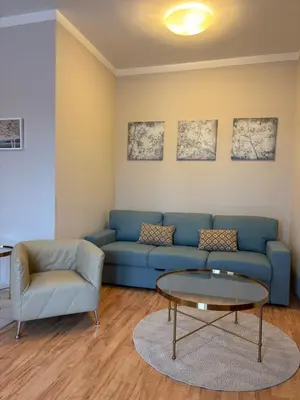 a living room with a blue couch and a table at Penzion Apartmány Resident in Poděbrady