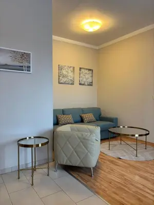 a living room with a couch and two tables at Penzion Apartmány Resident in Poděbrady