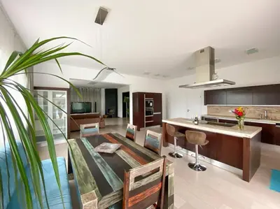 a living room with a kitchen and a table at Great spacious villa near Prague in Božkov