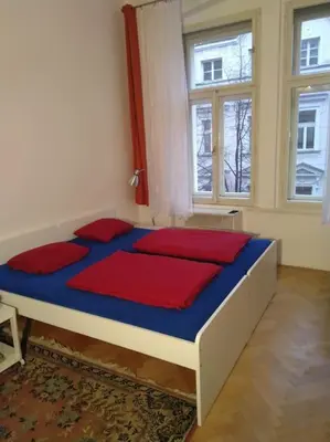 a bed in a room with two windows at Authentic, traditional airbnb in central Prague ! in Prague