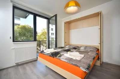 a bedroom with a bed and a large window at Appartment Waltrovka, free parking in Prague