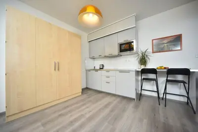 a kitchen with white cabinets and a table and chairs at Appartment Waltrovka, free parking in Prague