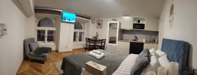 a living room with a gray couch and a kitchen at Apartment Prague Center in Prague