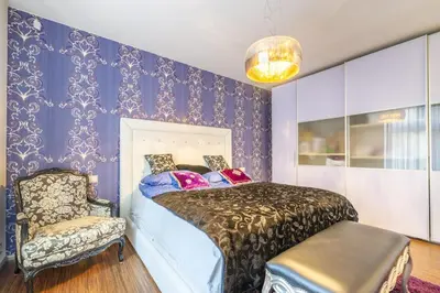 a bedroom with purple walls and a bed and a chair at Centrum luxury nice wiew, theras in Prague