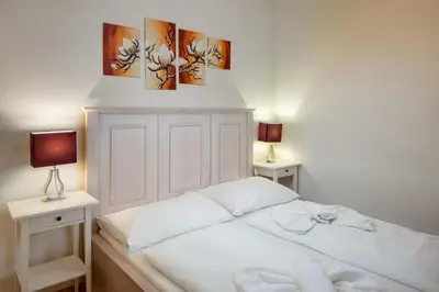 a white bed with two tables and two lamps at Havelska Old Town Residence in Prague