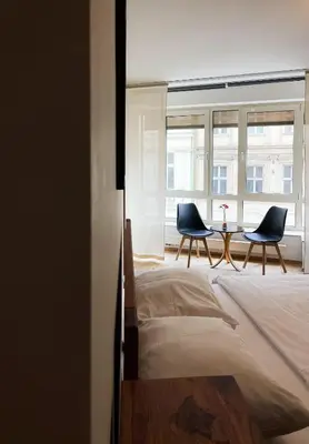 a bedroom with two chairs and a table in front of a window at Havelska Old Town Residence in Prague