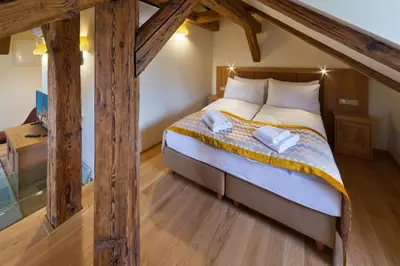 a bedroom with a large bed with wooden beams at Havelska Old Town Residence in Prague