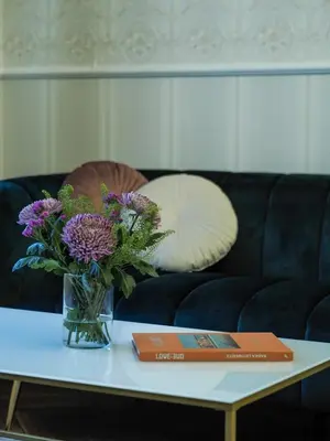 a vase of purple flowers on a table with a book at Stupartska - Premium Old Town Residence in Prague