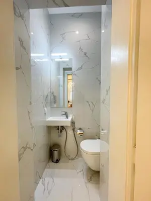 a white bathroom with a toilet and a sink at Stupartska - Premium Old Town Residence in Prague