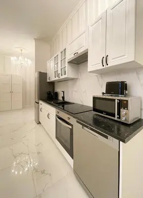 a kitchen with white cabinets and a microwave at Stupartska - Premium Old Town Residence in Prague