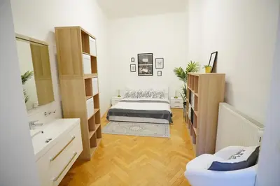 a bedroom with a bed and a sink and a mirror at NEW! Mucha 3BDR Flat in HEART of the City Center in Prague