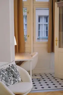 a room with a chair and a table and a door at NEW! Mucha 3BDR Flat in HEART of the City Center in Prague