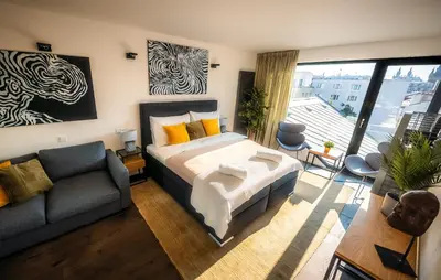 a bedroom with a king sized bed and a couch at 5BR+2Bath Old Town Loft Luxe Brickhouse, A/C in Prague