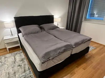 a bed with grey sheets and a black headboard in a bedroom at Quiet apartment in the centre in Prague