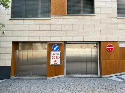 three garage doors on a building with signs on them at Quiet apartment in the centre in Prague